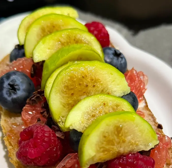 Toast topped with sliced green figs and berries