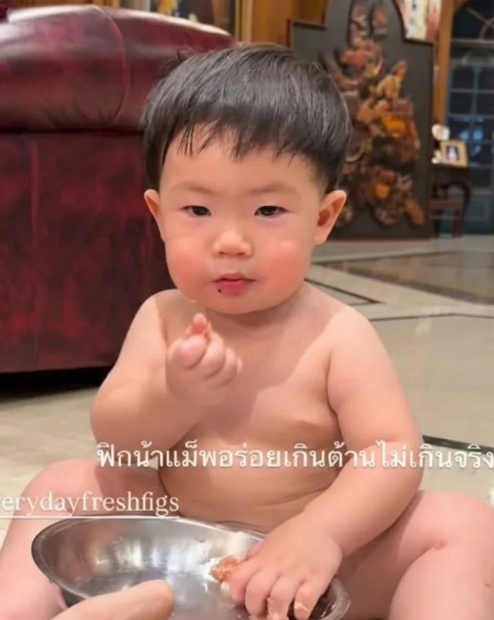 A little boy eating fresh figs from a bowl at home
