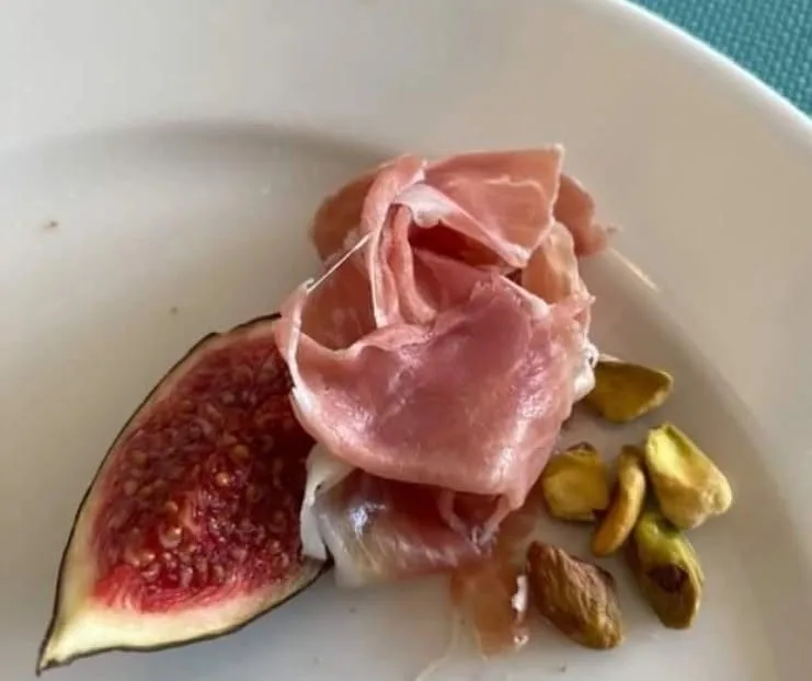 Fresh fig wedge with prosciutto and pistachios